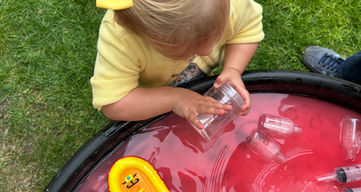 Child playing with fire rescue toys in water sensory play