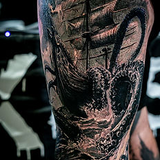 Detailed tattoo of a sailing ship and kraken