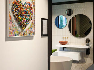 The showroom of Sanitair Design Center with a colorful, heart-shaped artwork by Mart Krijger on the wall.