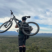 A man holding his bike looking at the desert