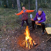 A father and son sitting around a campfire