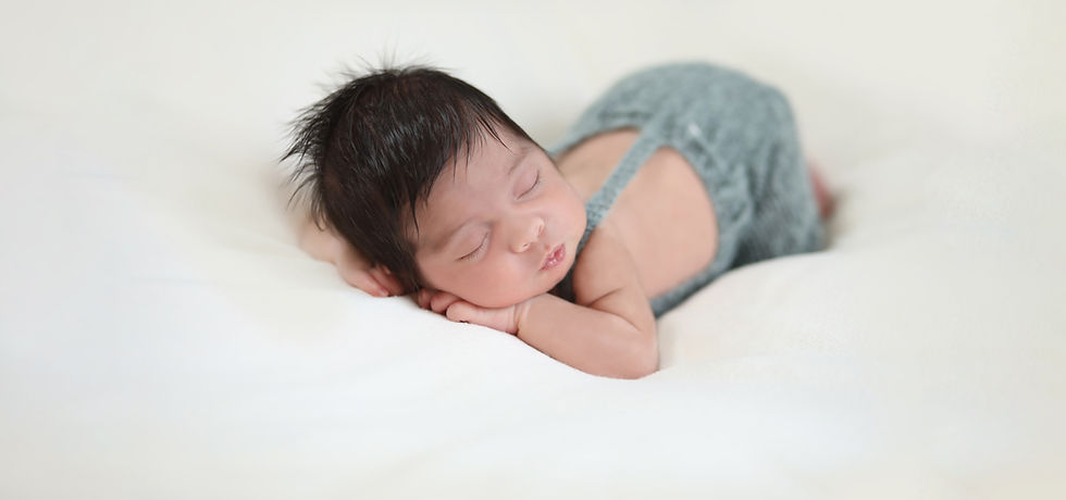Sleeping baby resting on elbows during newborn photography session