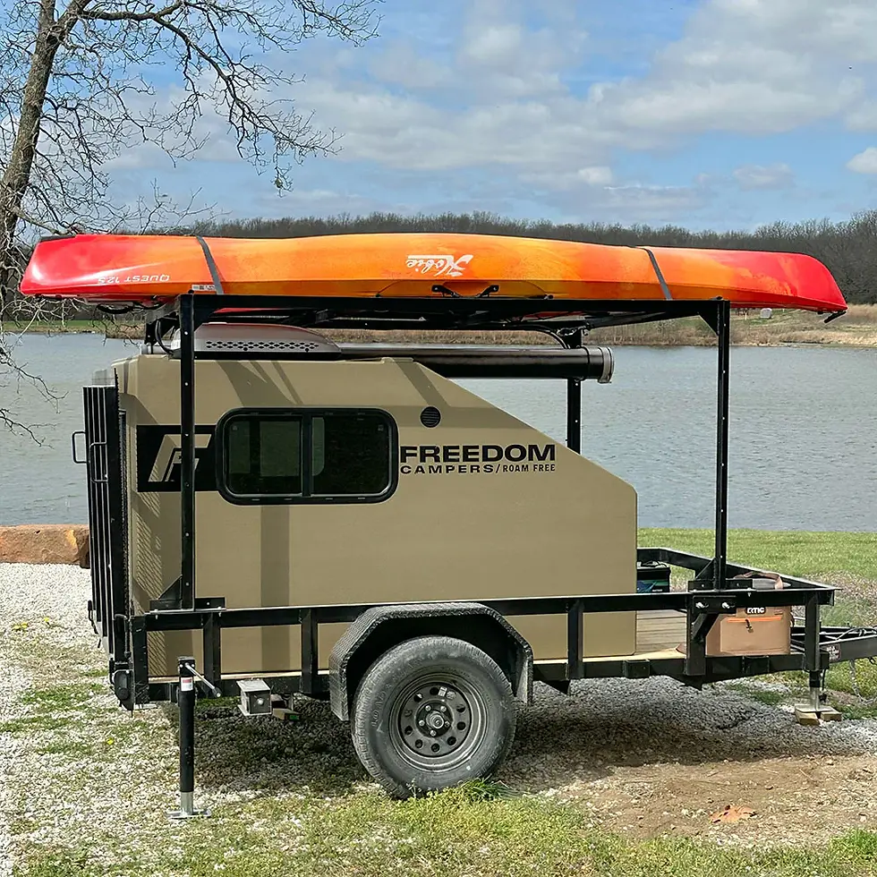 Eye-level view of a rugged off-road camper parked in a forest clearing