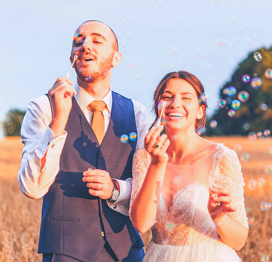 Hana et Pierre soufflant des bulles dans un champ, extrait de leur film de mariage