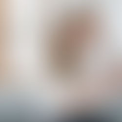 Vater und Mutter halten ihr Neugeborenes gemeinsam im Arm und blicken sich liebevoll an – Newbornshooting zuhause mit Fotograf Bad Ischl.