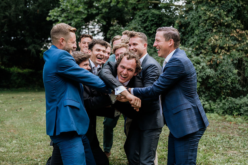 Der Bräutigam und seine Gäste lachen herzlich