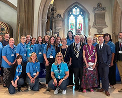 Taken inside Chelmsford Cathedral, this photo shows Witham Mayor cllr Paul Heath in his Mayors chains, with a lady dignitary either side of him, also in their chains. There are around a dozen people alongside them in blue t-shirts for Alzheimer's Society