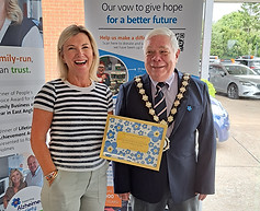 Witham Mayor Councillor Paul heath presenting a framed certificate to a lady from Prime Appointment for participating in the Dementia Awareness Week window competition
