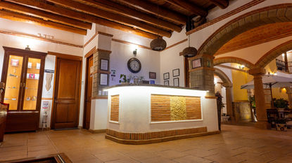 Lobby de hotel con mostrador de recepción y decoración rústica
