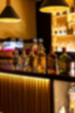 Botellas de licor en barra de bar iluminada