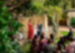 Ceremonia de boda en jardín, con pareja, oficiante e invitados.