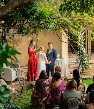 Boda exterior en jardín con novios y oficiante