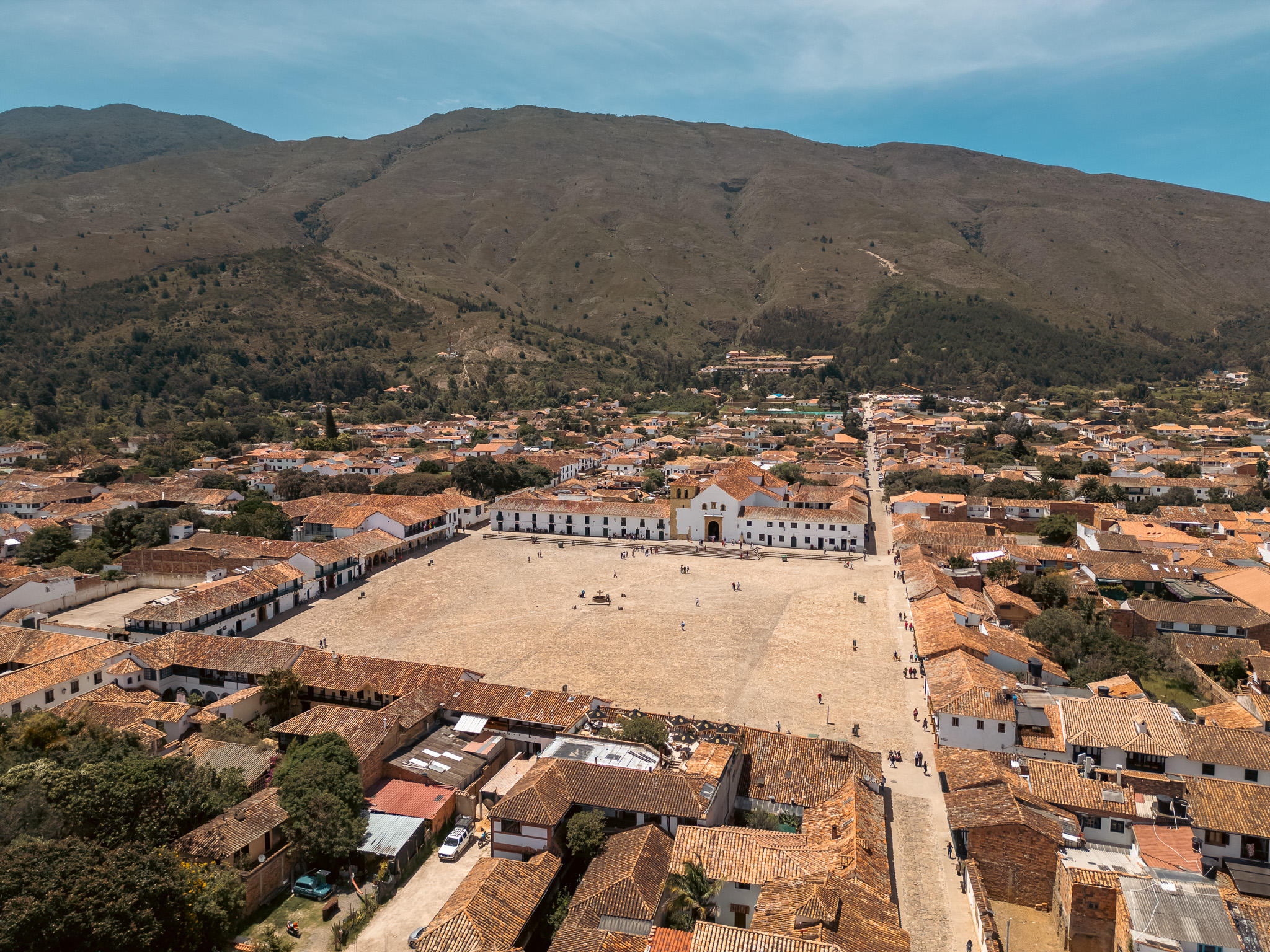 Plaza principal con edificios coloniales y montañas