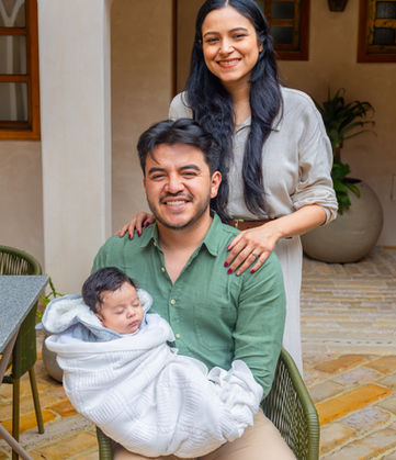 Padres sonrientes con bebé en brazos