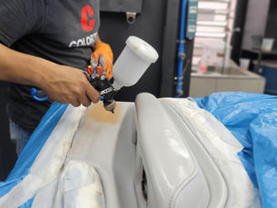 Uma pessoa realizando uma pintura de uma parte de couro de um carro com tintas a base de agua Colortek