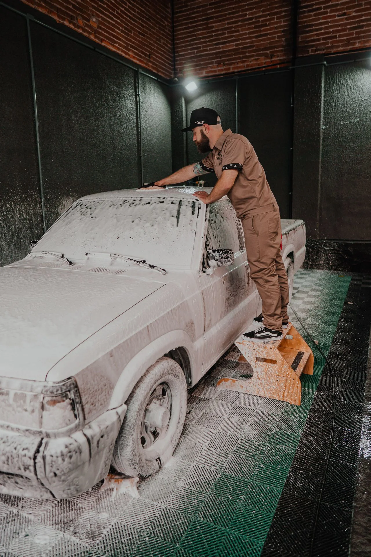 etailer utilizando a Escada de Trabalho Média Krakoss Garage com segurança para polir o teto de um veículo, garantindo a ergonomia e o alcance ideal em partes altas do carro na estética automotiva