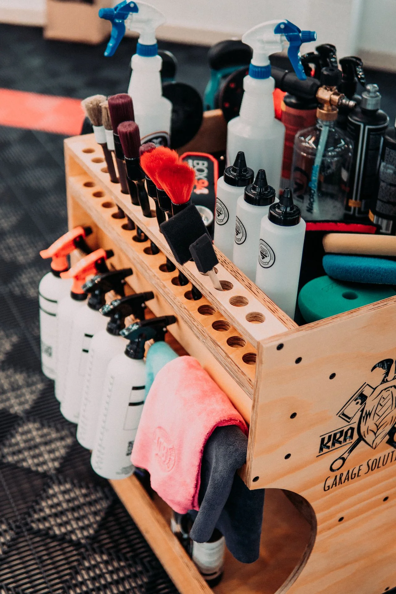 Detalhe do Carrinho Fast Cart Detail (FastCart02) em Compensado Naval, mostrando as gavetas SlowMotion abertas para armazenamento de microfibras e rodízios Colson amarelos de alta resistência