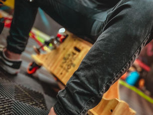 Profissional de Estética automotiva realizando polimento na parte baixa de um carro usando um banco com rodas melhorando a ergonomia