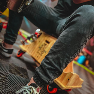 Profissional de Estética automotiva realizando polimento na parte baixa de um carro usando um banco com rodas melhorando a ergonomia