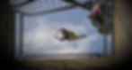 A man doing parkour jumping between two railings from below