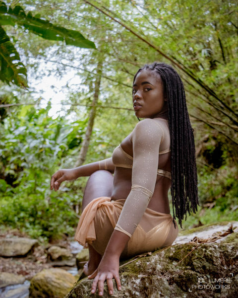 Woman sitting on rock looking back at the camera