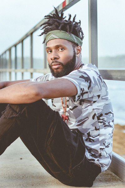 Man sitting on boardwalk looking at camera