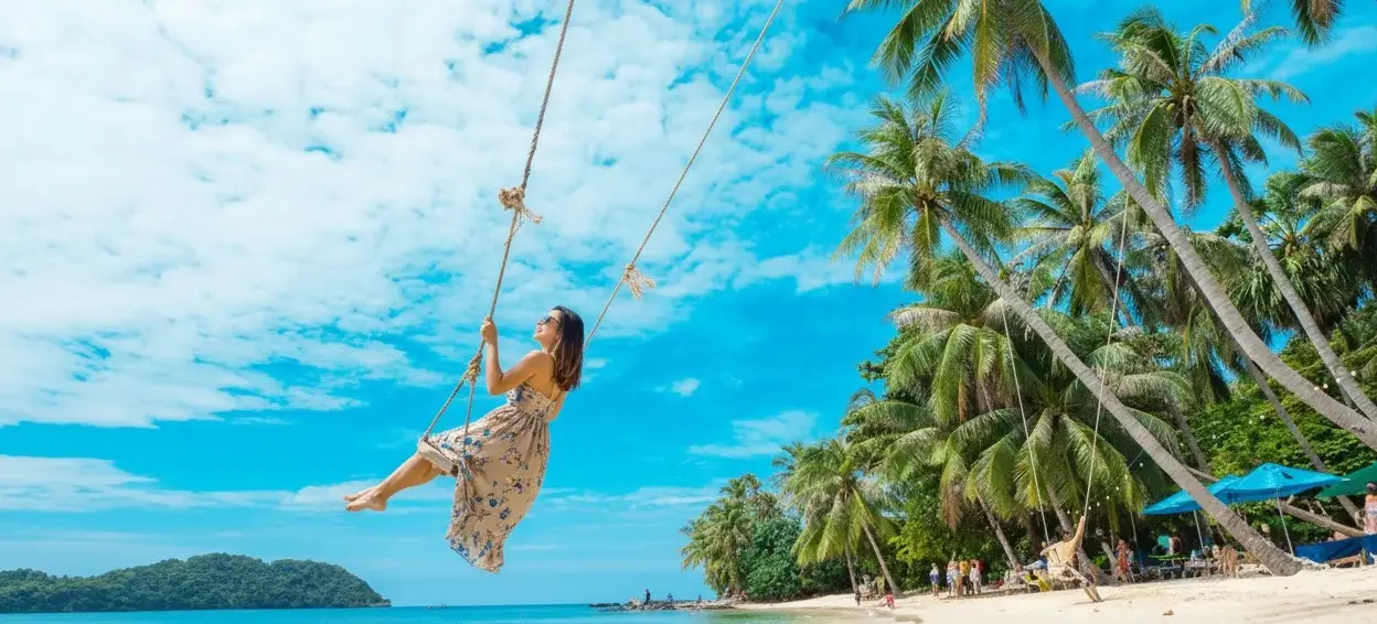 May Rut Island Woman swinging above the sea among the palm tree.webp