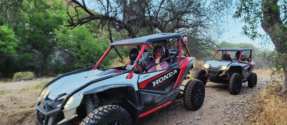 Two Honda Talon side-by-sides winds through the trees and rugged desert terrain on a guided Desert Monsters Tours adventure