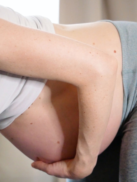 kvinna med en gravid mage, hon håller handen på sin mage