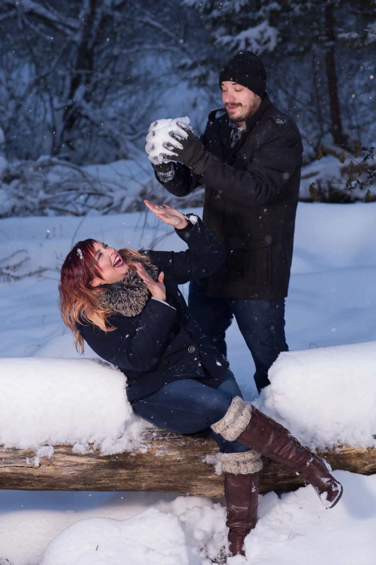 man dropping snowball on woman