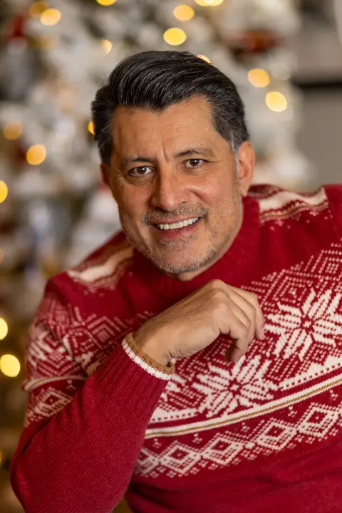 Christmas headshot in front of decorated tree