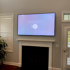 tv mounted with wires concealed above fireplace