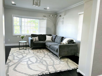 Modern living room with a grey sectional and patterned rug
