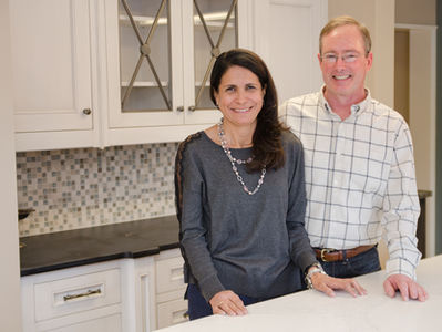 Mary and Jim Regan standing side by side, smiling at the camera in the Wayside Kitchens Showroom