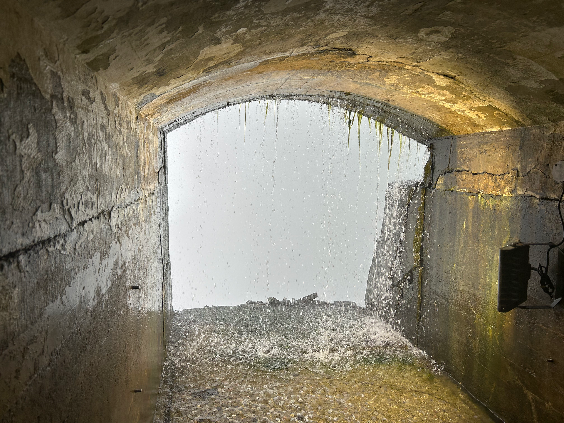 One of two tunnels cut into the wall behind the falls.