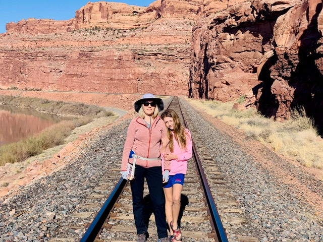 moab family trip planning. Mother and daughter stand along the railroad crossing on the way to Jeep Arch