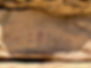 Ancient rock art with red and brown humanoid figures on a sandstone wall. Earthy tones dominate the scene, conveying a historical mood. Petroglyphs near I-70 in Thompson Springs Utah.