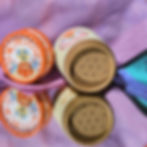 Two open Scrubber dry shampoo containers on purple fabric.