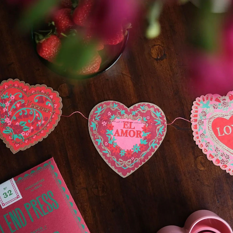 East End Press printed heart-shaped paper garland with El Amor text on table surface.