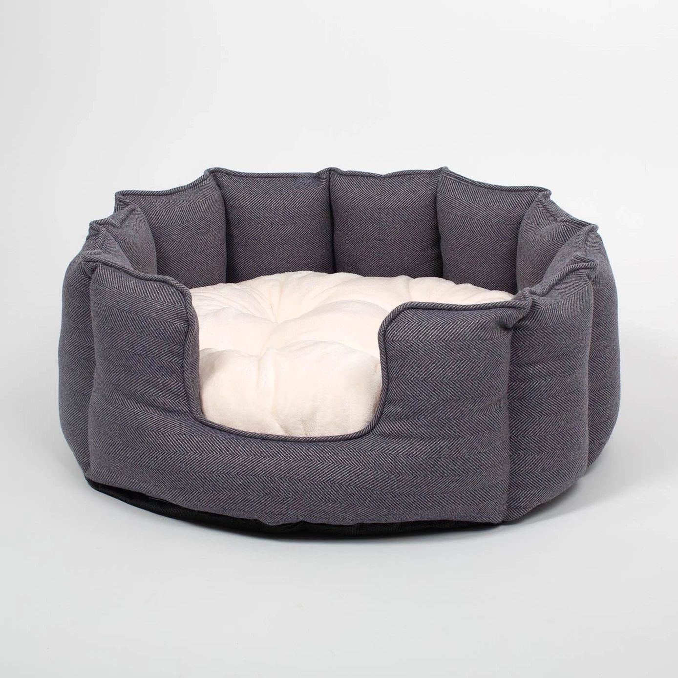 Luxury herringbone tweed cat bed with a cream cushion on a white background.