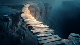 A weathered timber bridge spanning a deep canyon at dawn