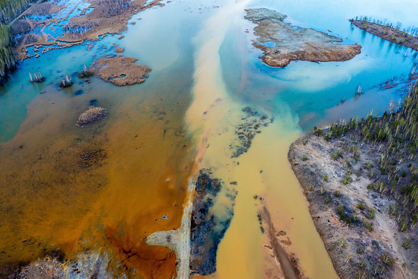 Acid rivers flowing from an industrial copper mine pollute the environment. Orange soil is