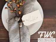 Thanksgiving table setting with decorative napkin, fall accents, and thank you tag, representing gratitude from Fritz Wahlfield Construction