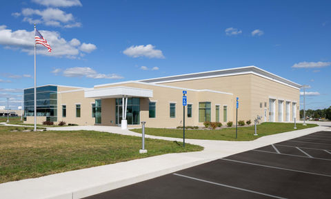 Modern building with parking lot and blue sky.