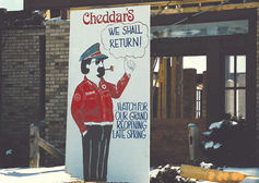 Vintage Cheddar’s “We Shall Return” sign displayed at restaurant entrance during rebuild following fire in Kentwood, Michigan