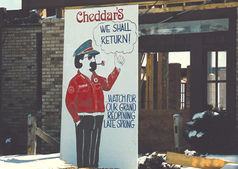 Vintage Cheddar’s “We Shall Return” sign displayed at restaurant entrance during rebuild following fire in Kentwood, Michigan