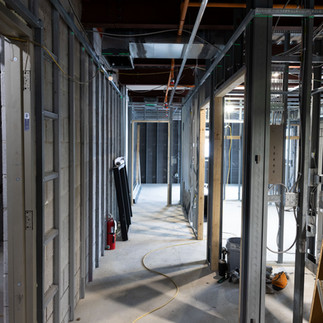 Hallway framing and mechanical systems in progress inside mixed-use building