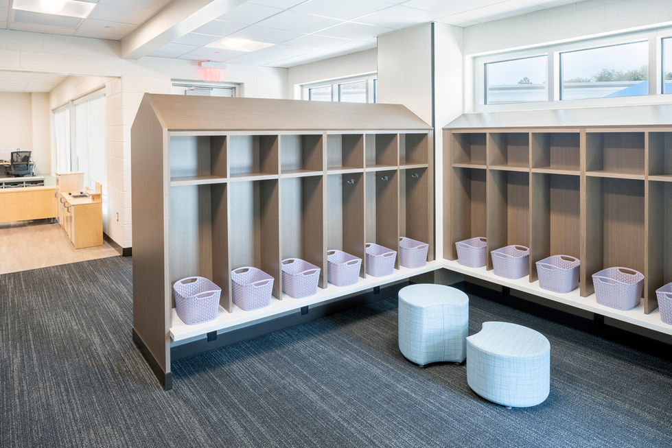 Modern interior with wooden cubbies and round stools.