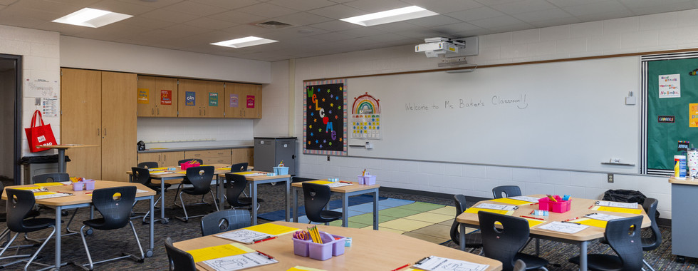 Elementary classroom with tables and chairs ready for students