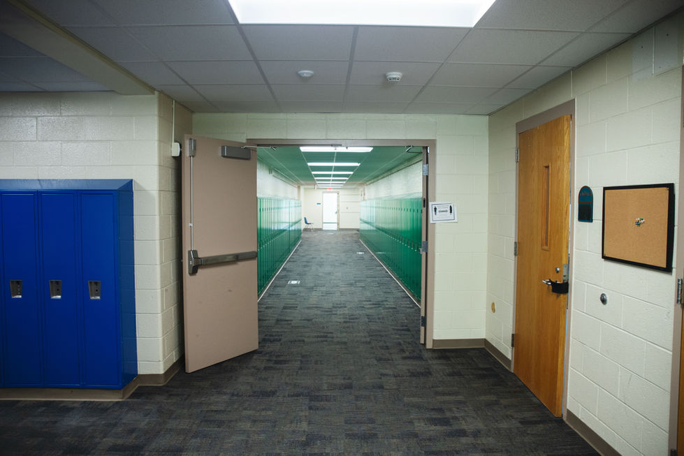 Hallway with green walls and gray carpet.